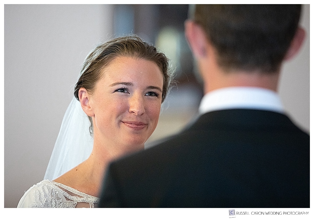 A bride smiles at her groom during their wedding ceremony