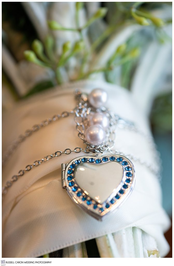 locket wrapped around the handle of a bridal bouquet