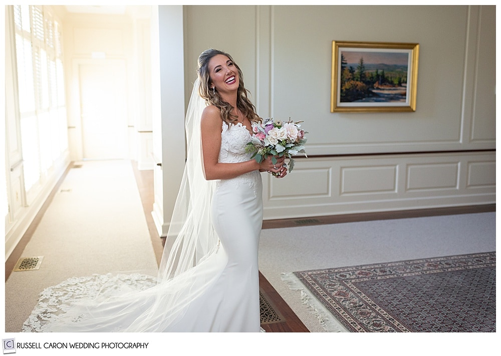 beautiful bride, fully dressed, holding her bouquet, smiling at the camera