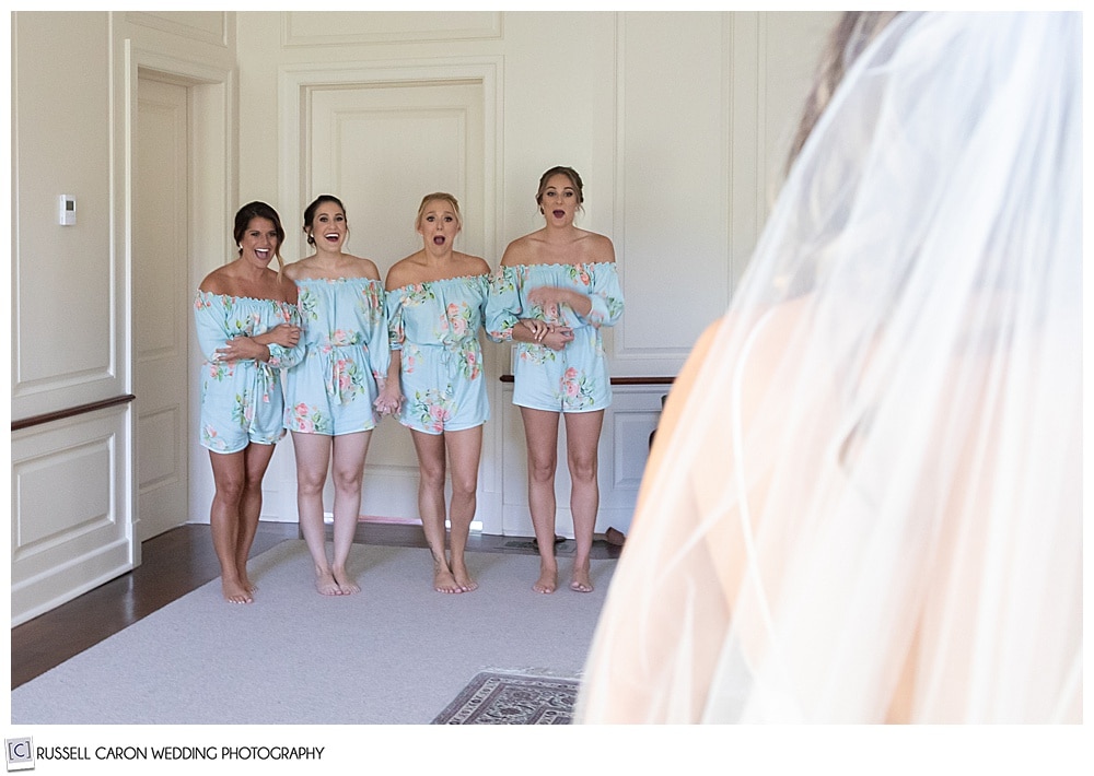 4 bridesmaids in mint rompers, reacting to the bride revealing herself fully dressed