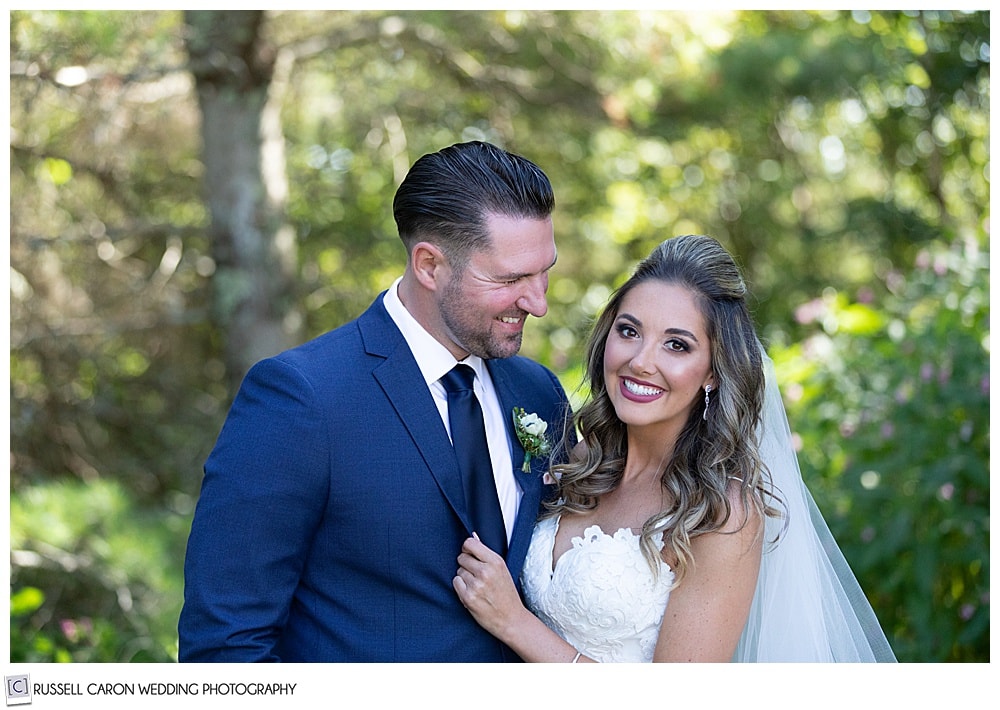 bride and groom, their arms about each other's waists, groom is looking at the bride, bride is looking at the camera, just after their first look