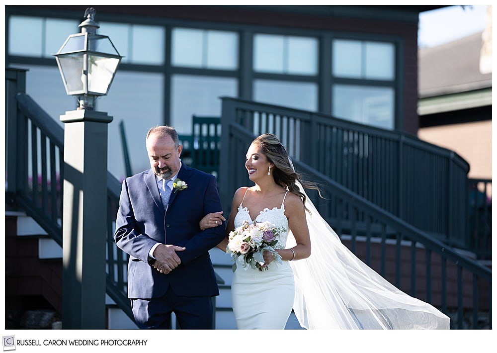 bride and her father coming down the steps as they approach the aisle at an elegant point lookout wedding ceremony