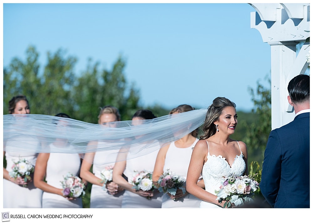 bride's veil blows during an elegant point lookout wedding ceremony outdoors