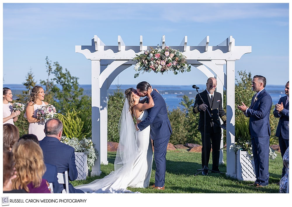 bride and groom during their first kiss at their elegant point lookout wedding ceremony, north port, Maine