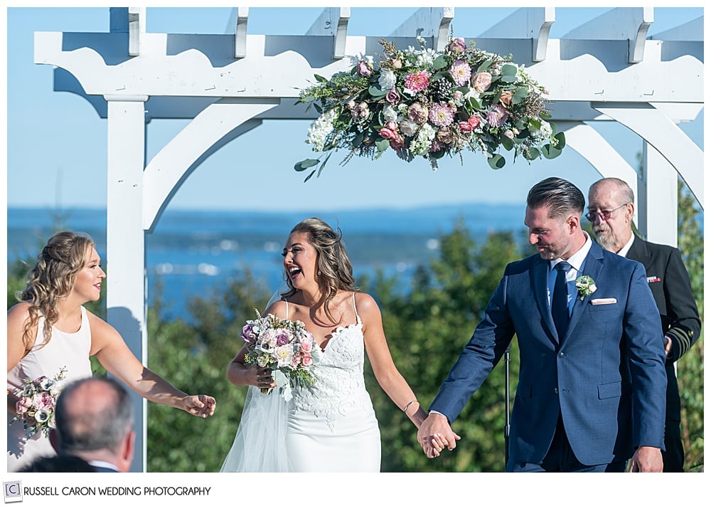 bride smiling at her maid of honor, just before her recessional