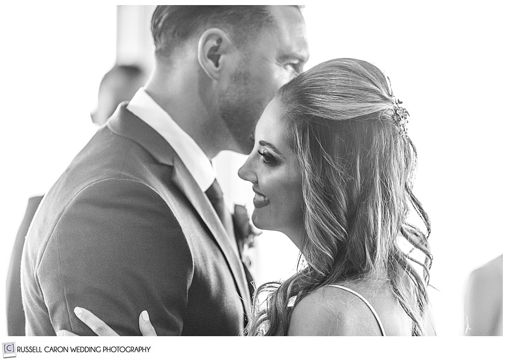 black and white photo of bride smiling during her first dance with her new husband