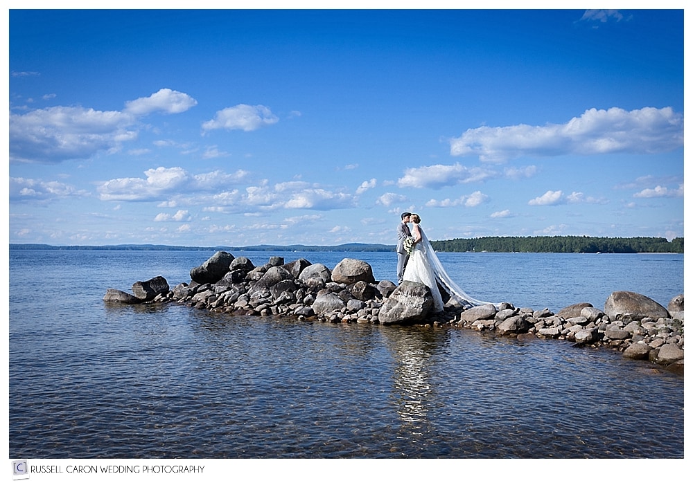 bride and groom on the rocks in Sebago Lake, Maine