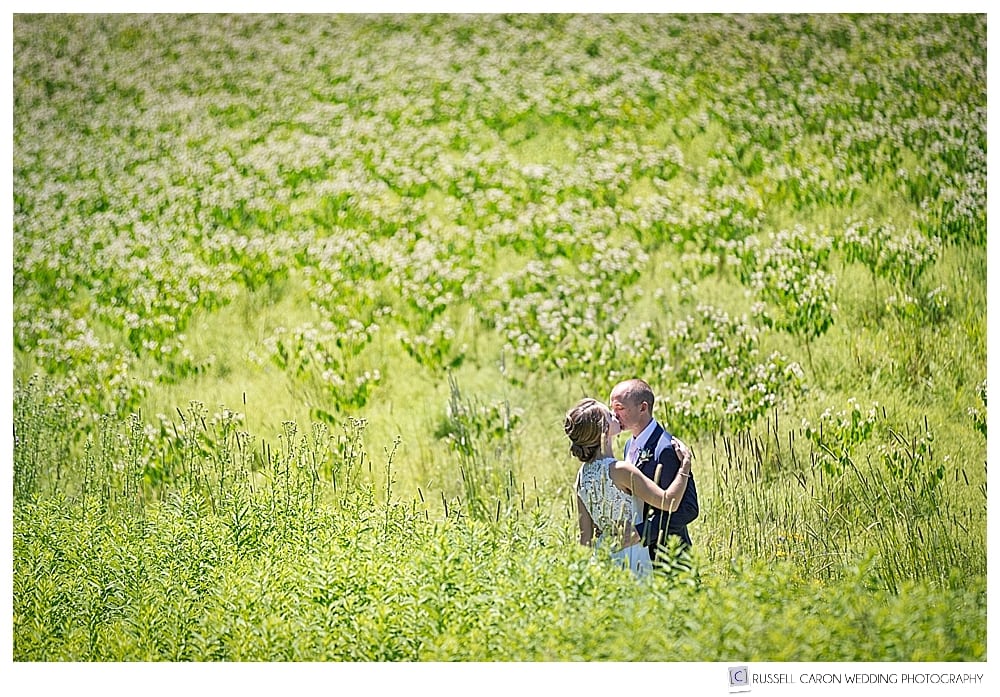 bride and groom kissing in a field at Gilsland Farm Audubon Center, Falmouth, Maine