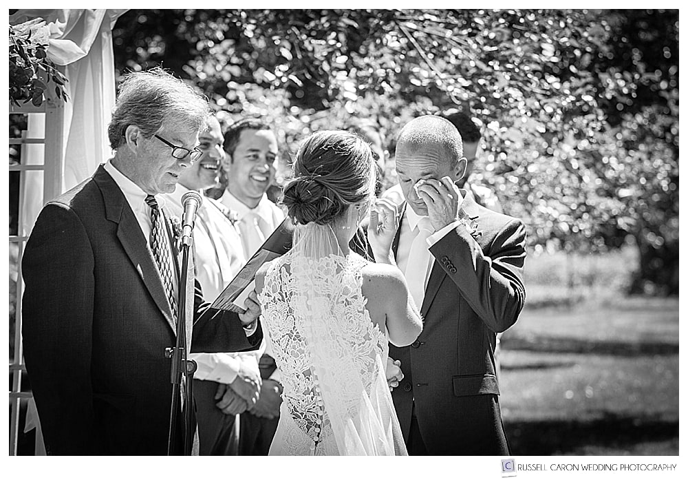 groom wipes a tear during an outdoor ceremony at the Gilsland Farm Audubon Center. Falmouth Maine wedding photographers