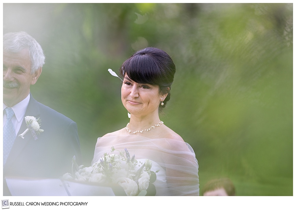 photo of the bride through the apple blossoms