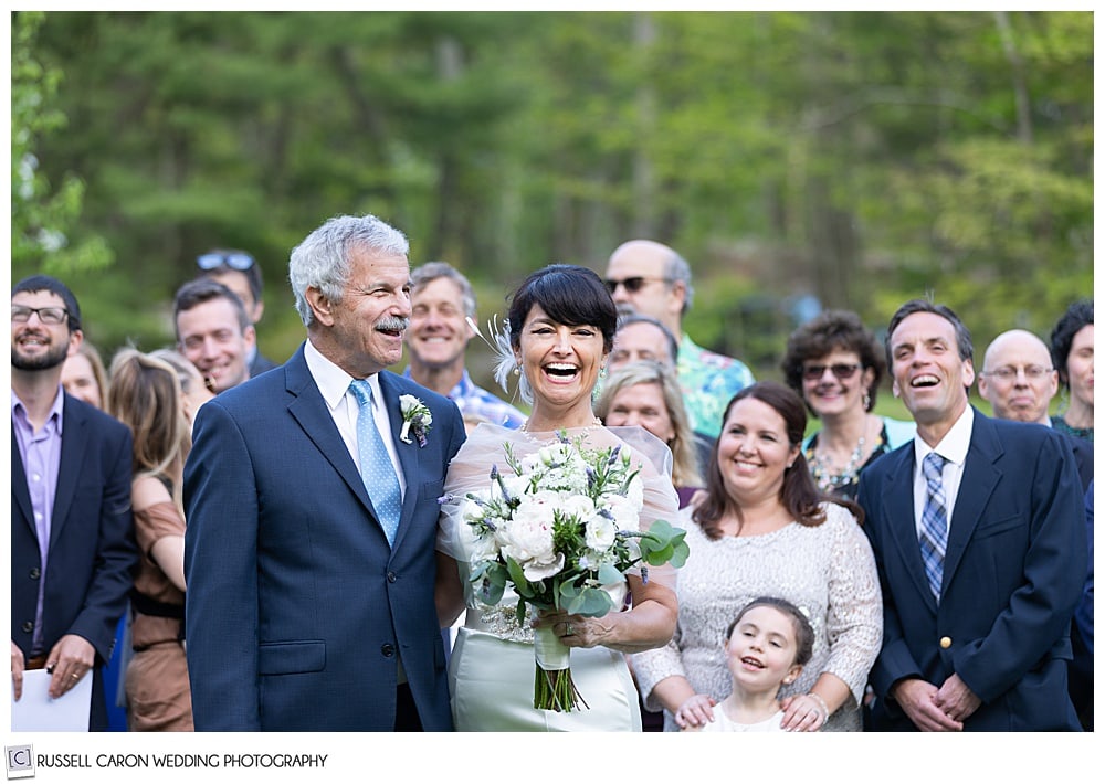 bride and groom laughing with friends and family