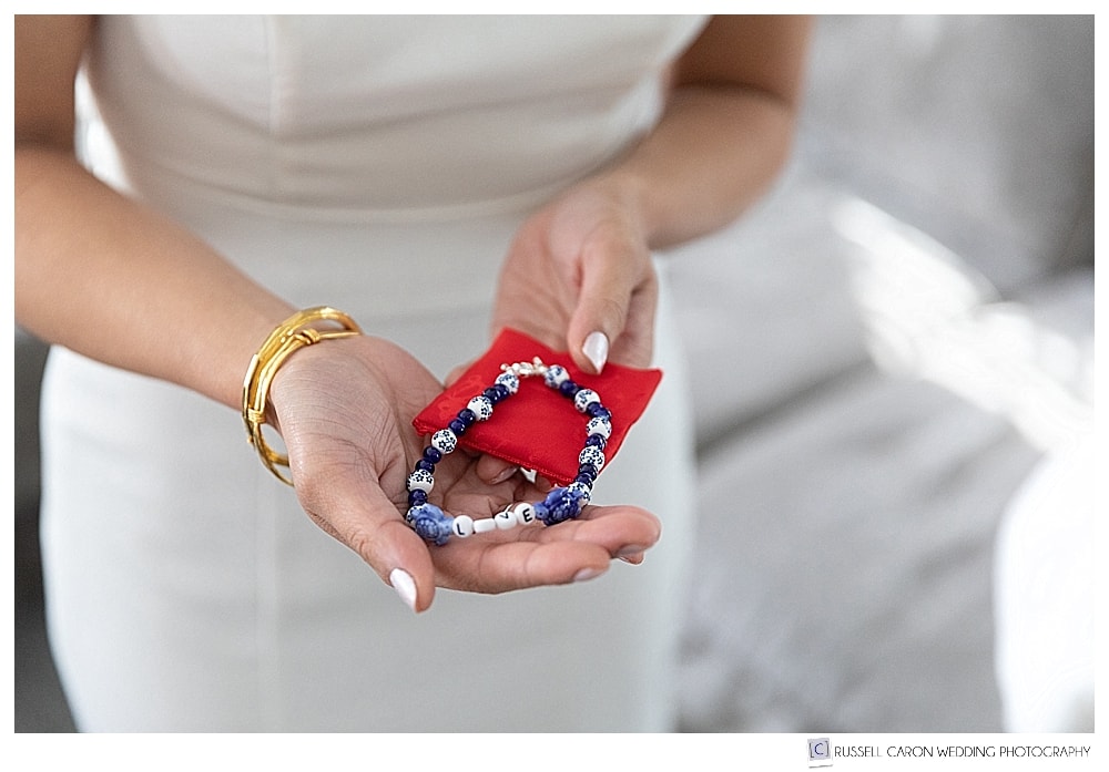 bride holding a blue and white anklet with red pouch