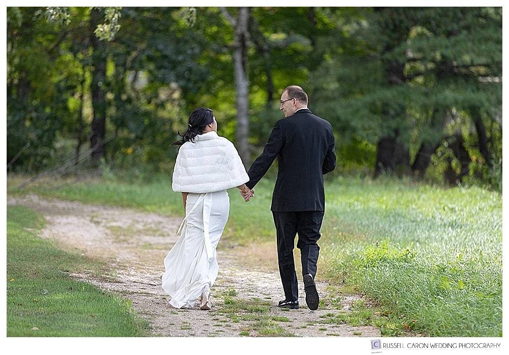 bride and groom walking away holding hands