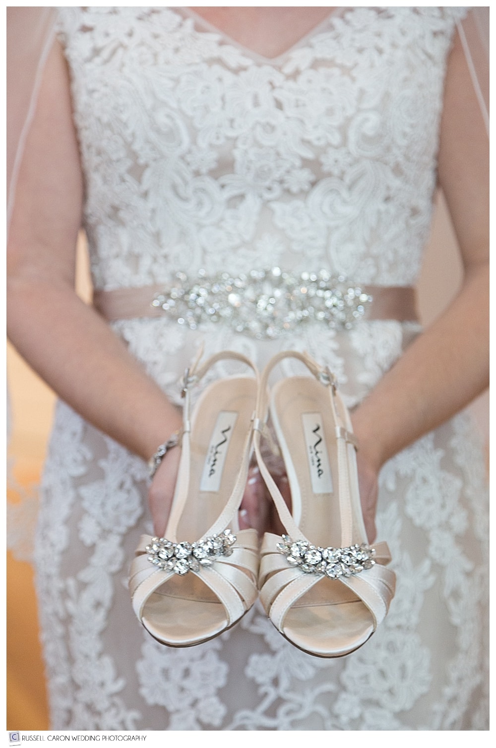 bride holding wedding shoes