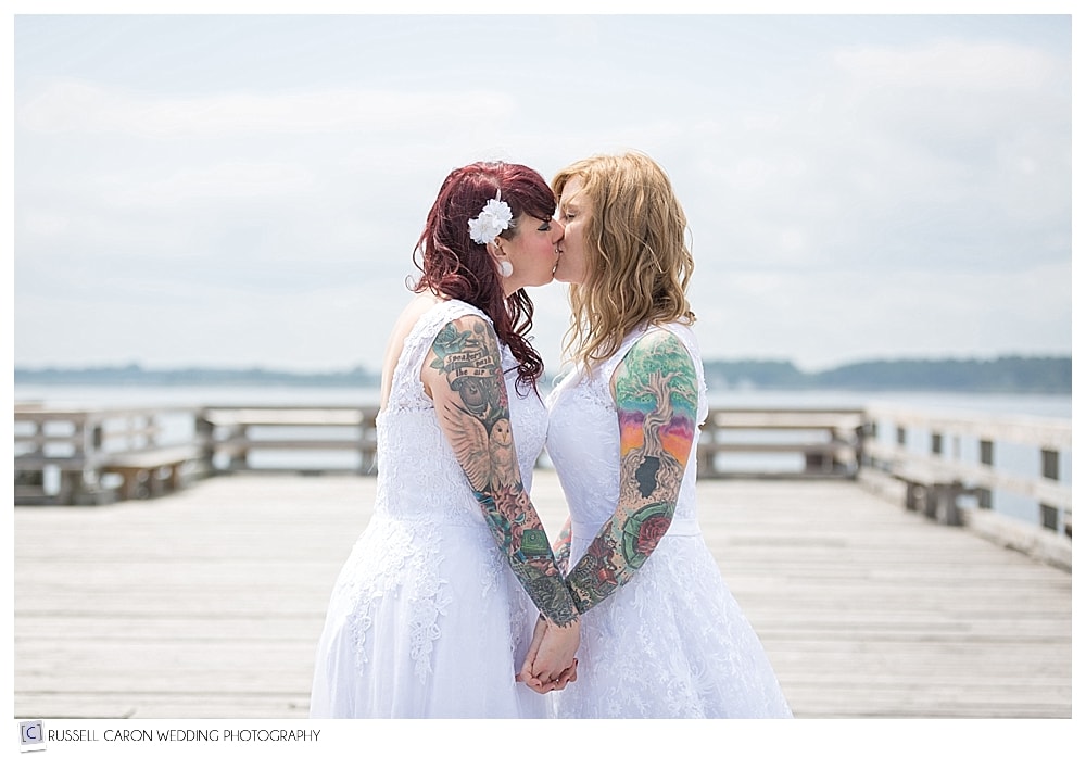 brides holding hands and kissing at Fort Foster Kittery Maine wedding