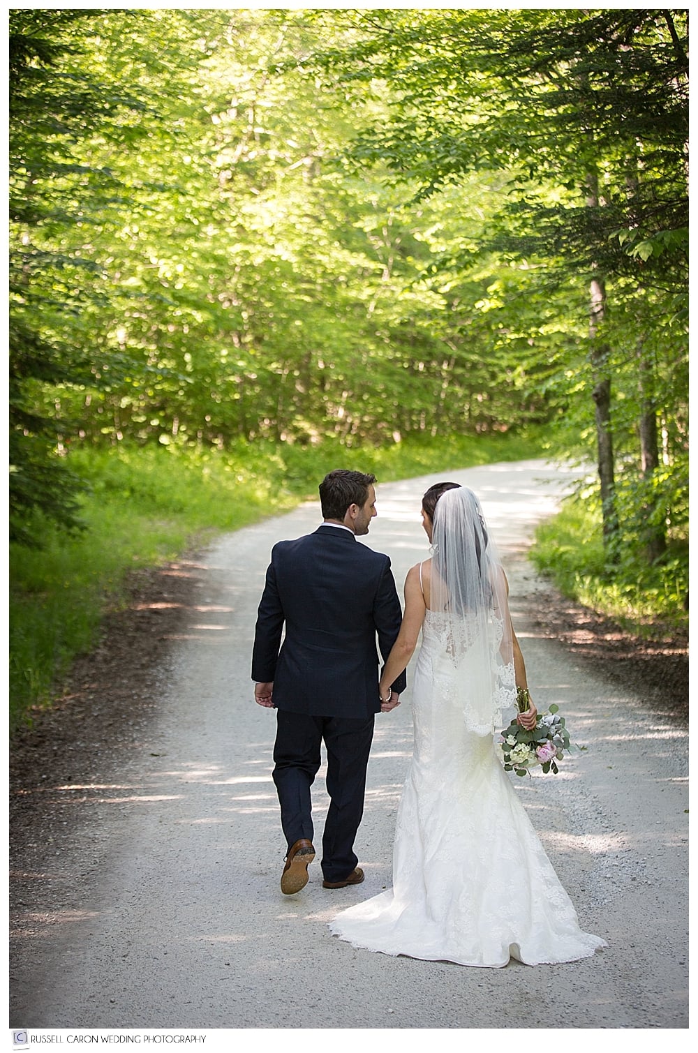 bride-and-groom-walking-hand-in-hand-up-dirt-road