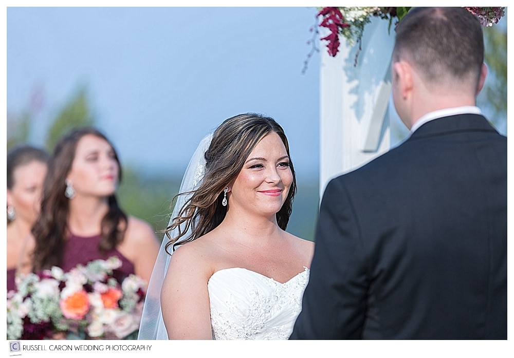bride smiling at groom during outdoor wedding ceremony