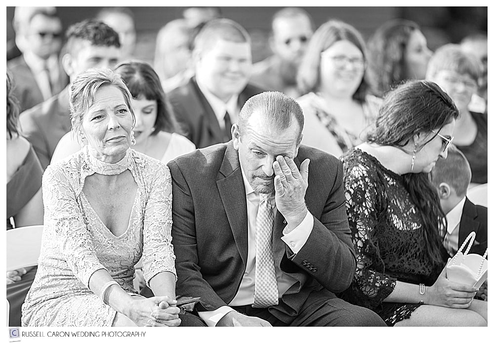 father of the bride wipes a tear during wedding ceremony