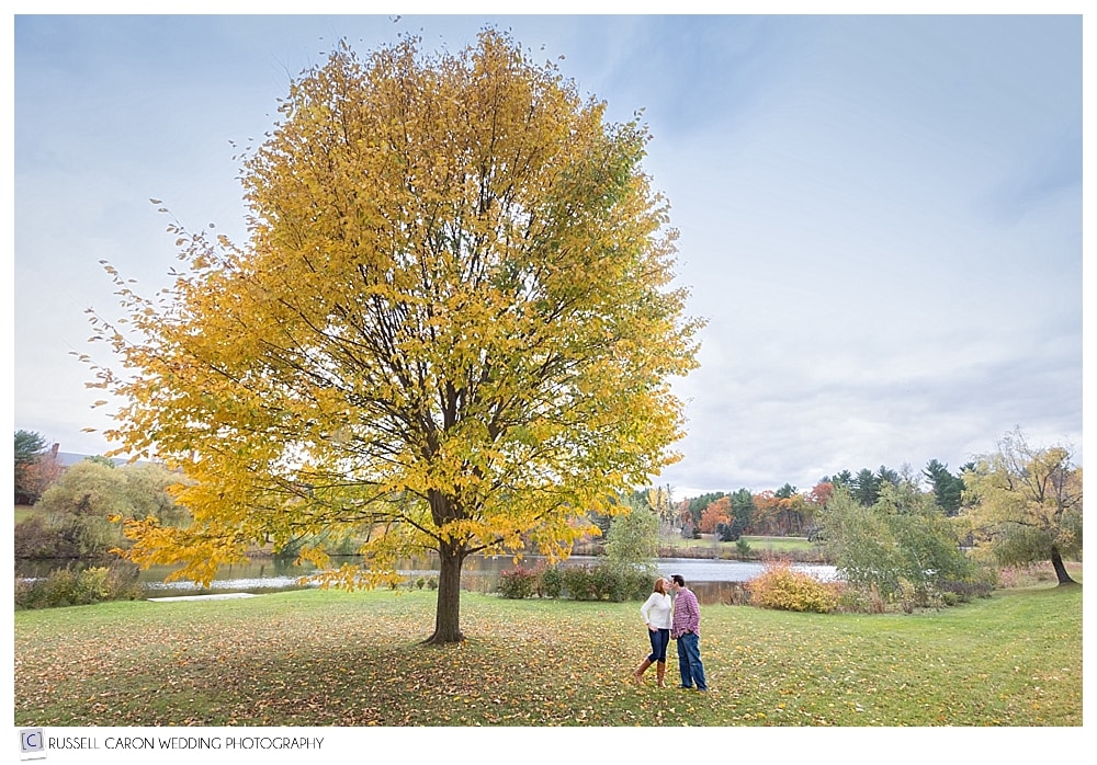 man and woman next to tree with beautiful fall foliage