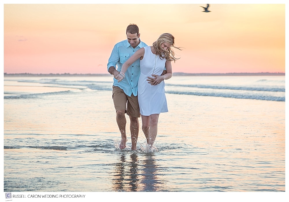 Maine engaged couple in the ocean at sunrise