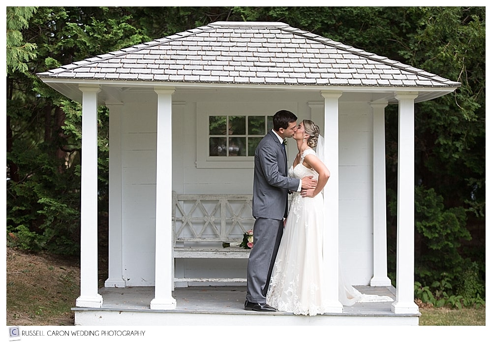 bride and groom kissing on a porch