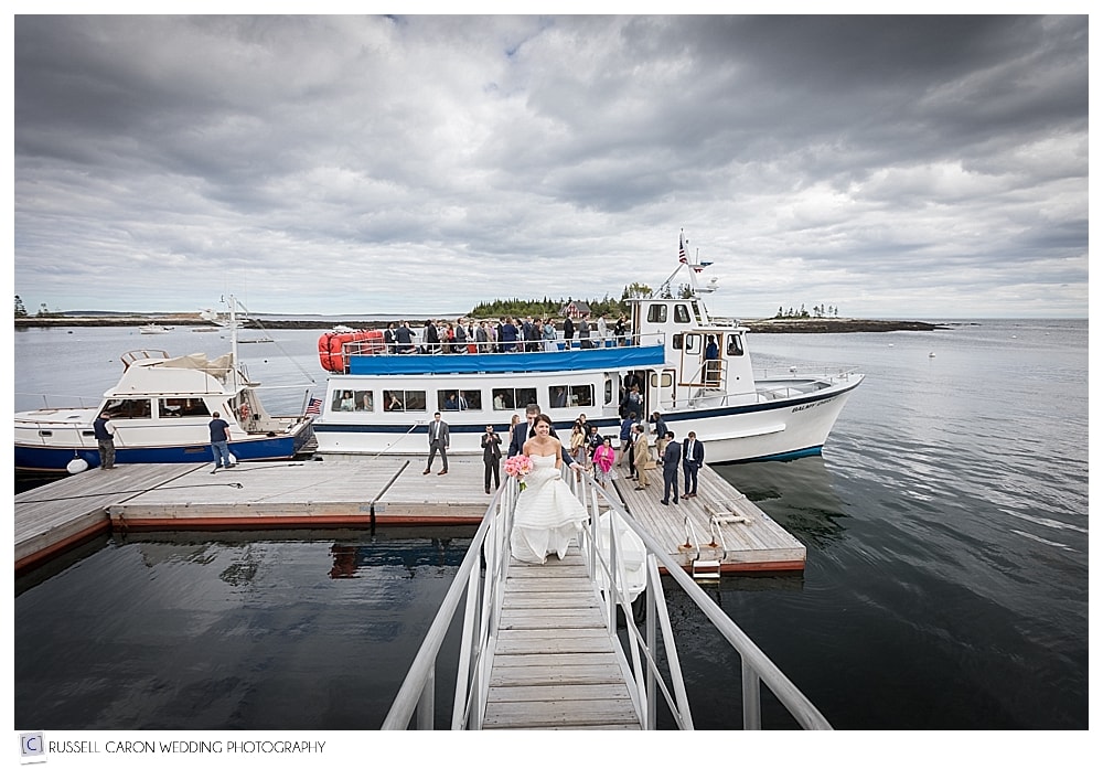 Bride and weddings guests disembarking boat at Newagen Seaside Inn, Southport, Maine