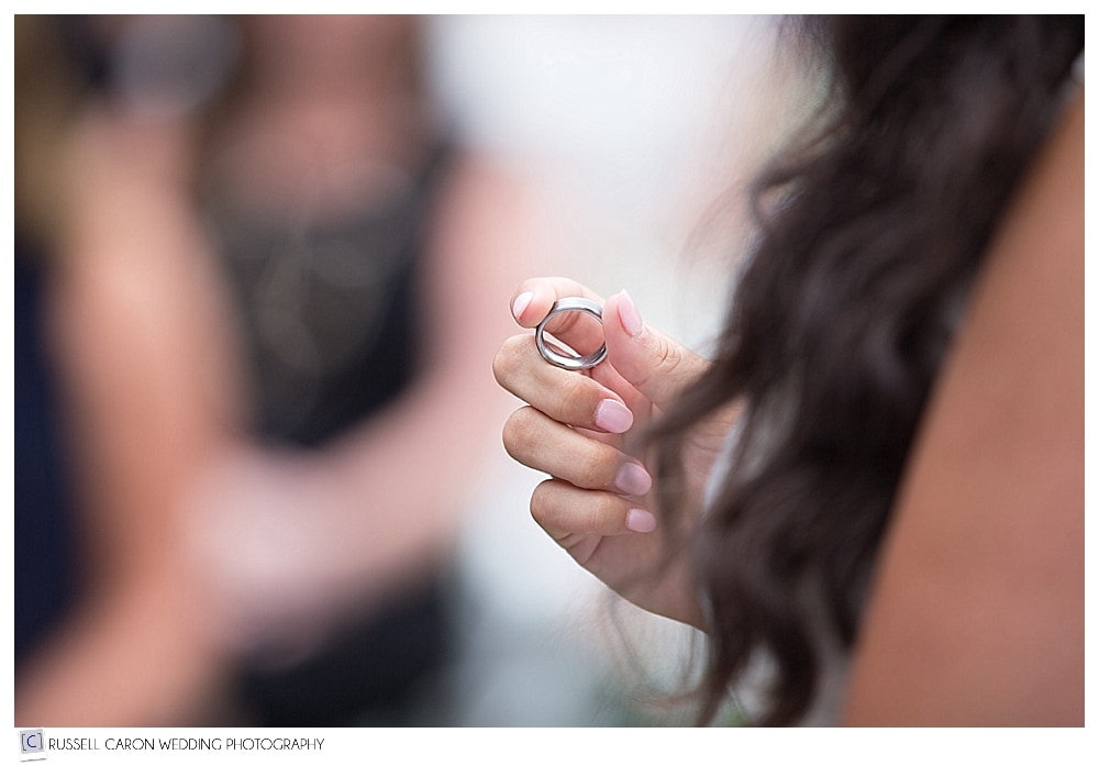 bride holding groom's wedding band during ring exchange