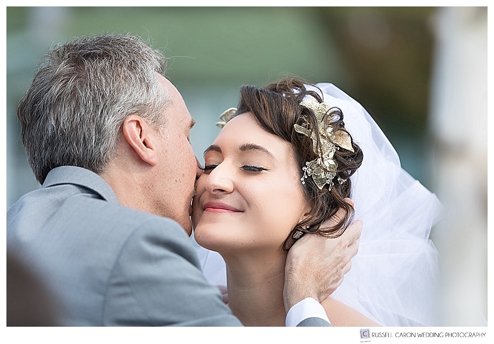 bride's father kisses her as he gives her away