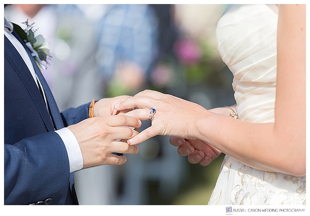 groom puts ring on bride's finger