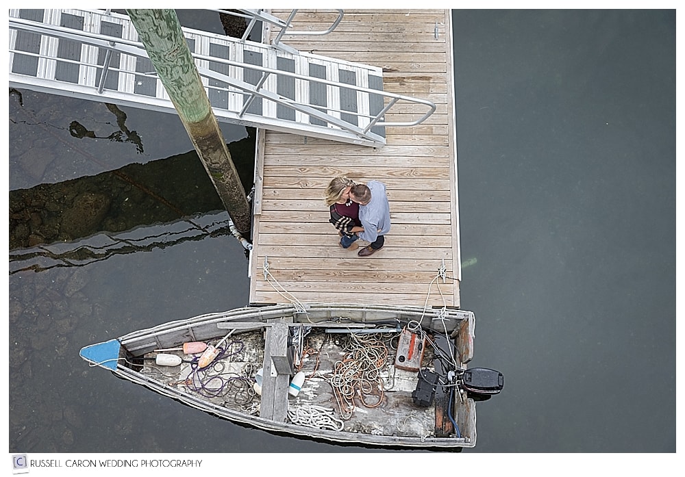 man and woman standing on a dock, photographed from above, during Perkins Cove engagement session