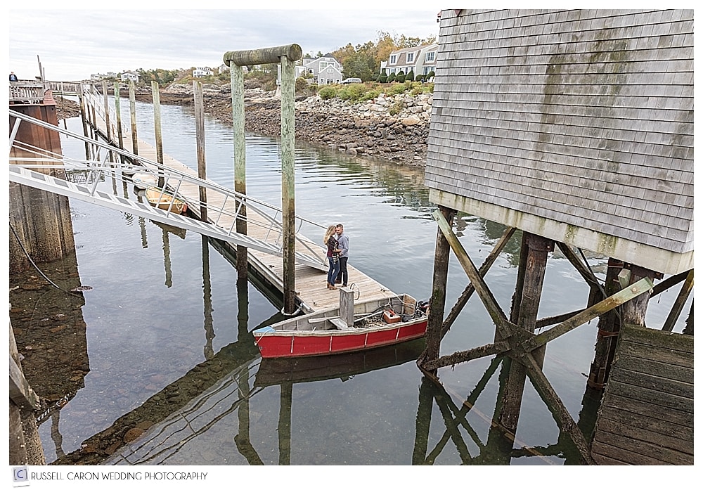 couple kissing on a dock during a Perkins Cove engagement session