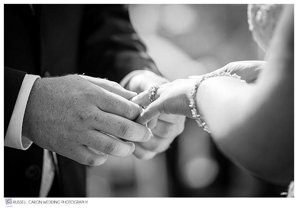 groom-puts-wedding-ring-on-bride's-finger