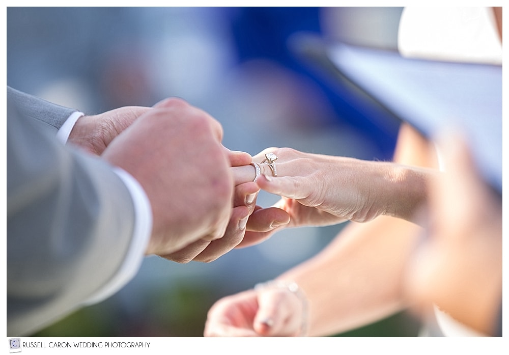groom putting wedding ring on bride's finger