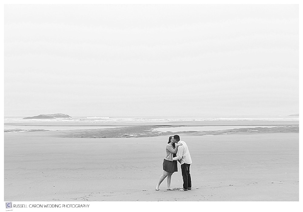 man and woman kissing on the beach