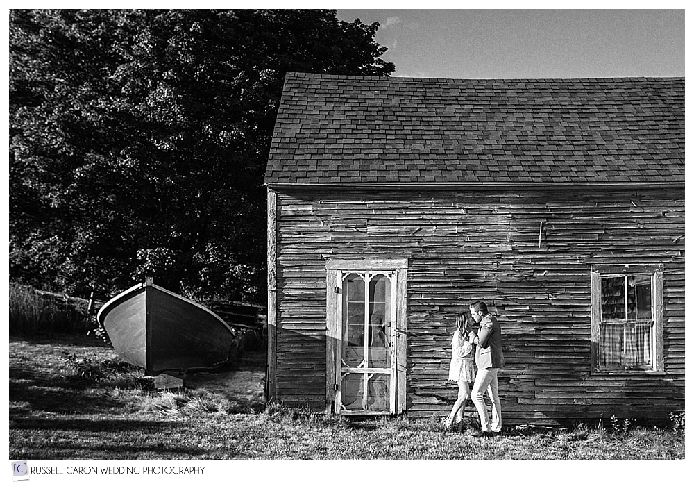 man and woman in front of old house, kissing