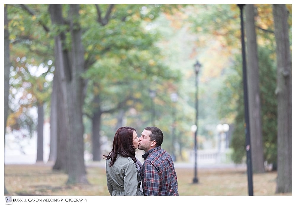 man and woman kissing in deering oaks park