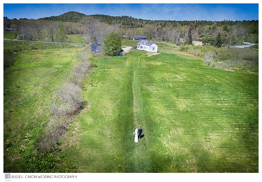 drone photo of bride and groom walking on the Maine coast