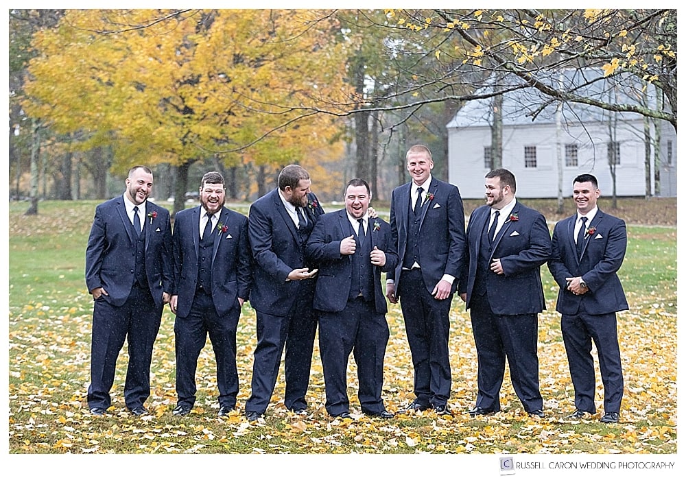groom and groomsmen laughing together in the fall foliage