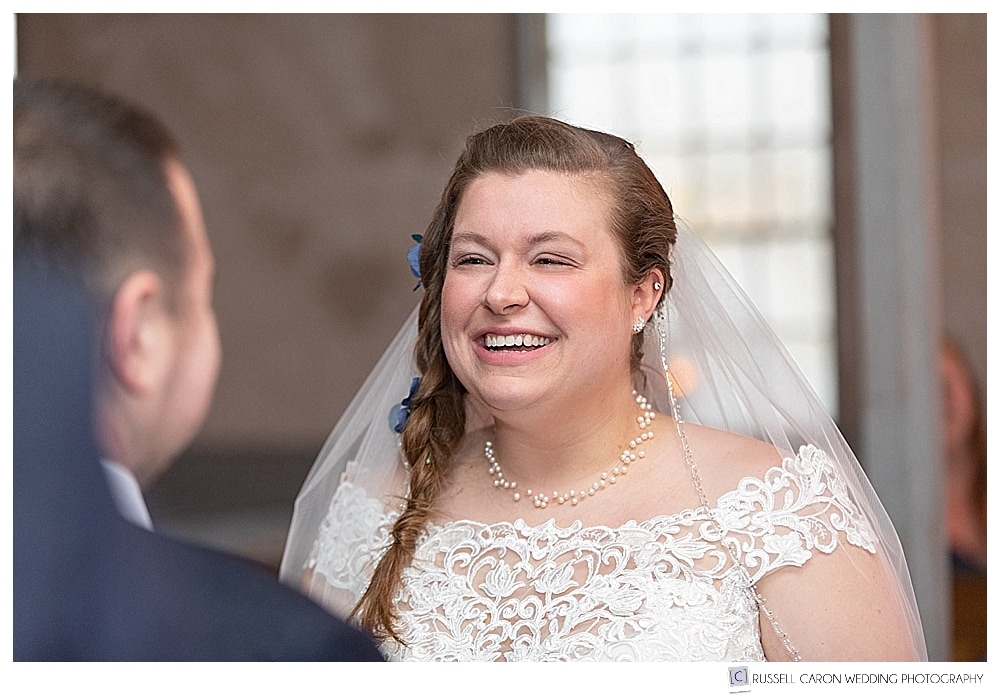 bride smiling at groom during wedding ceremony