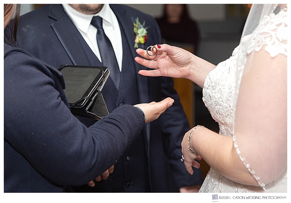 bride holding groom's wedding ring