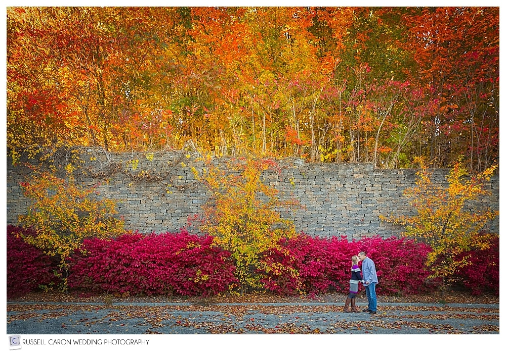 couple kissing amid beautiful fall foliage