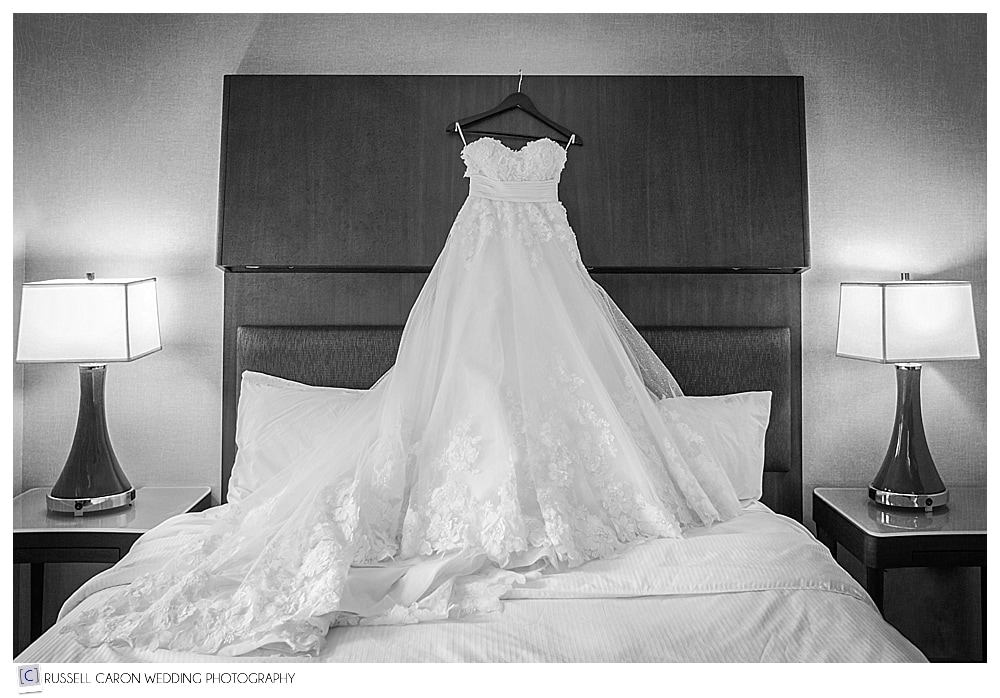 wedding dress hanging over bed