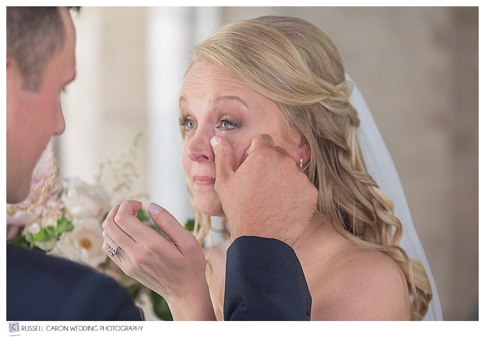groom brushes away brides tear during wedding day first look