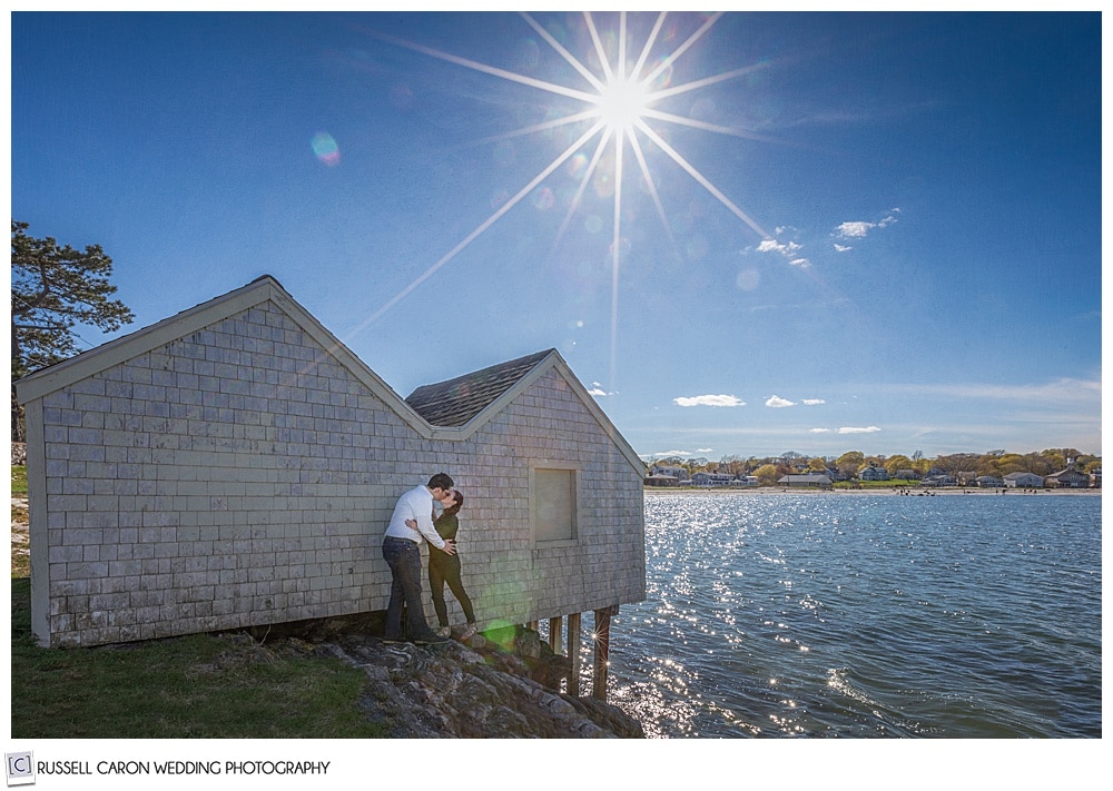 a man and woman are kissing each other in front of a building at willard beach, south Portland Maine