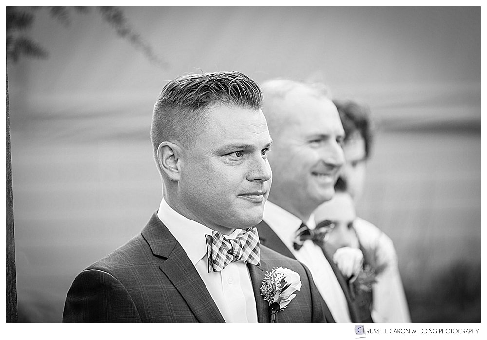 black and white photo of groom waiting for his bride