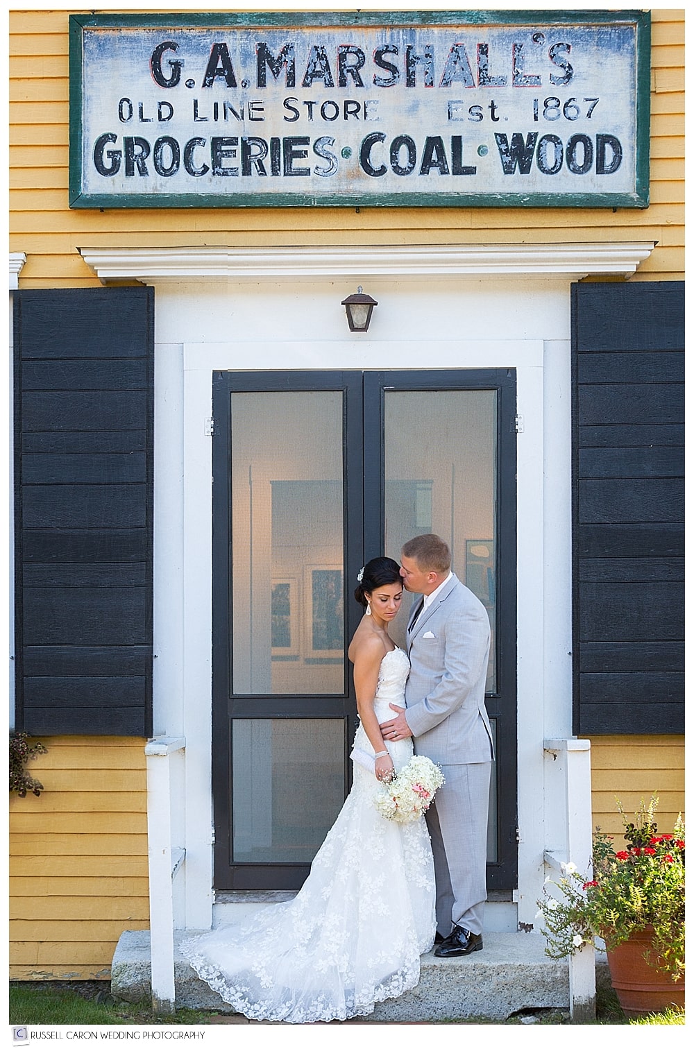 bride and groom in front of yellow building