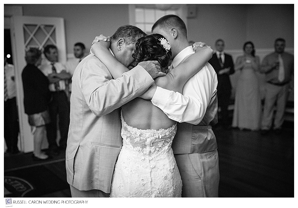 groom, his father, and bride hugging