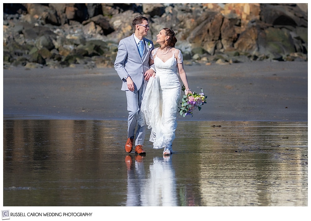 bride and groom walking on the beach