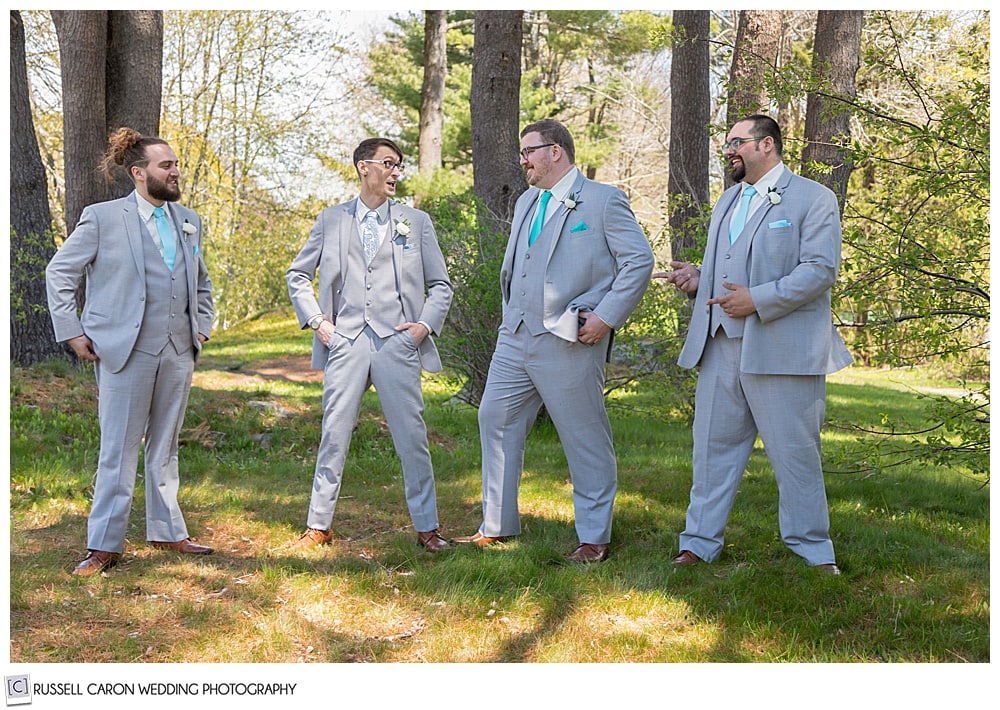 groom and groomsmen standing together and laughing