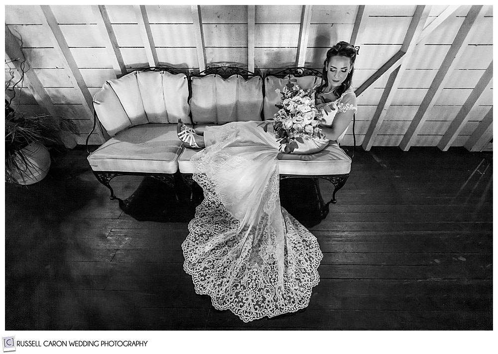 black and white photo of bride on a chaise holding her bouquet